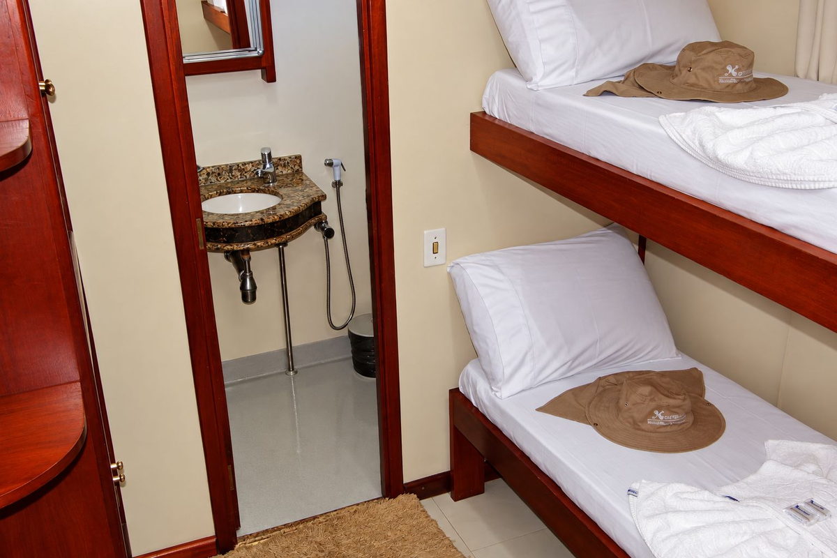 Camarote do barco-hotel Xaraiés com camas e banheiro privativo